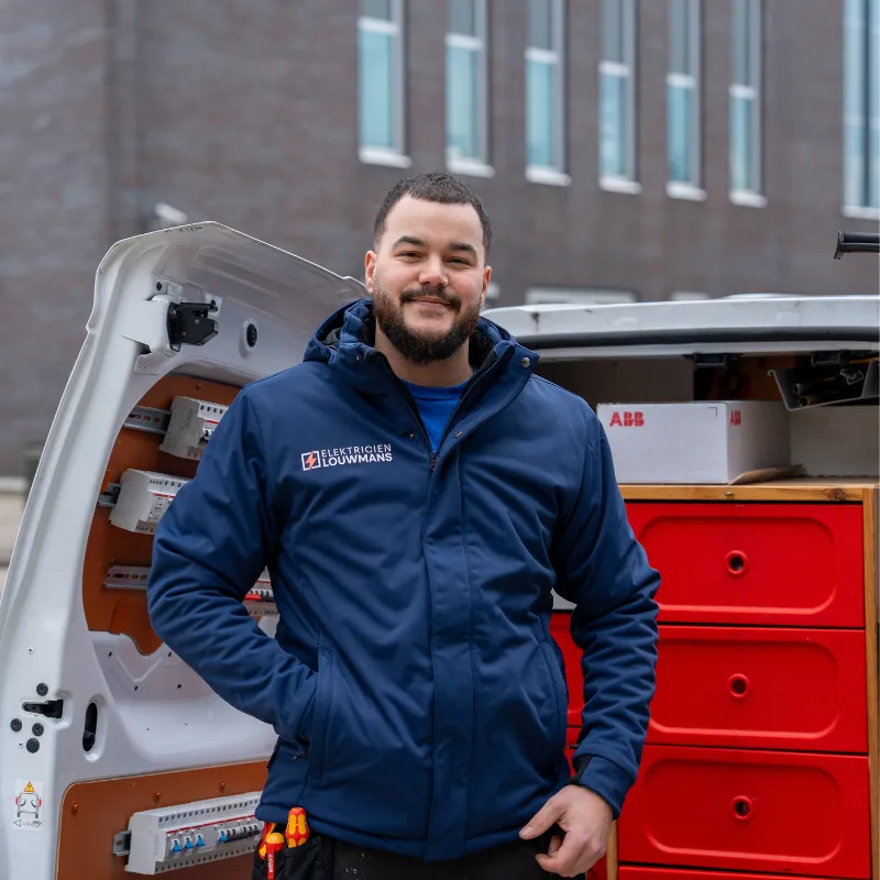 Elektricien van Louwmans bij de bedrijfsbus vol installatiemateriaal