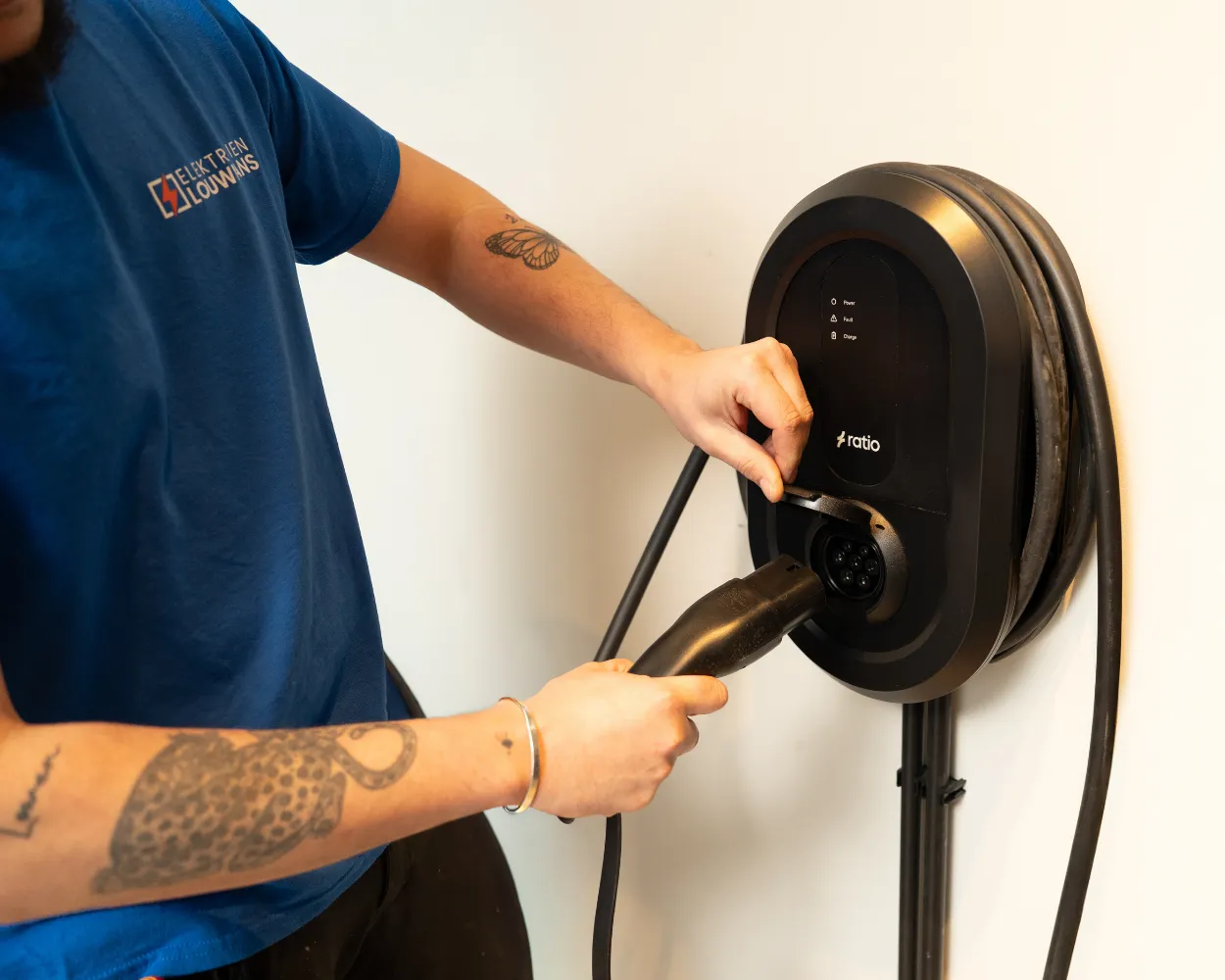 Elektricien hangt een laadpaal aan de muur