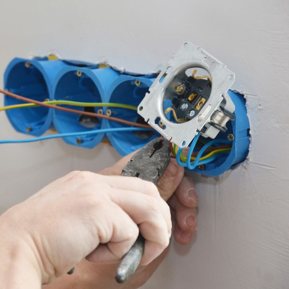 Elektricien sluit nieuwe bedrading aan in inbouwdozen