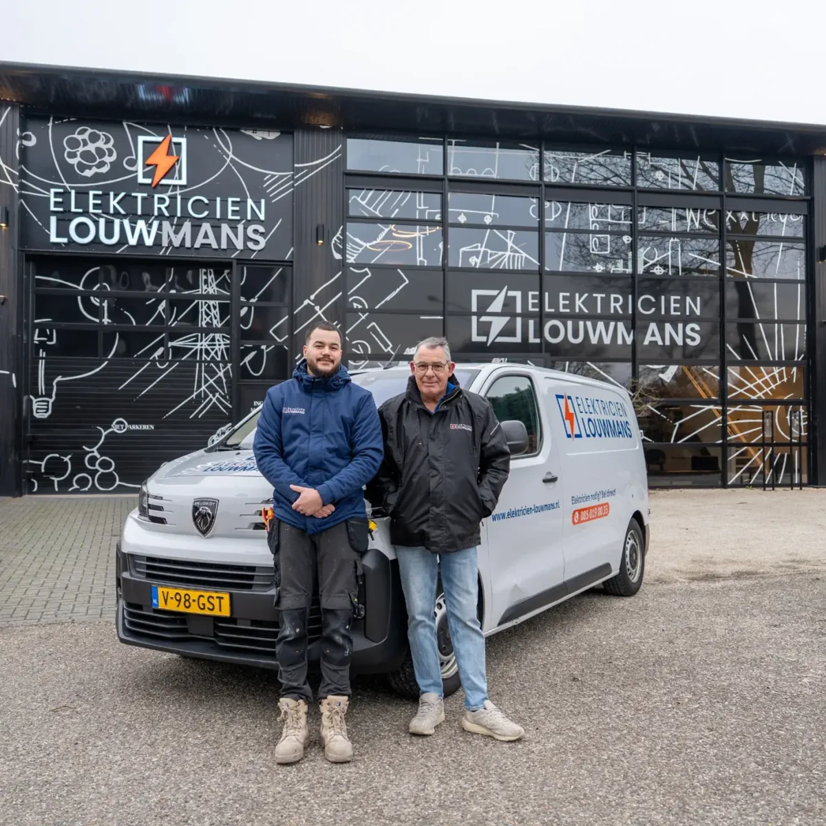 Twee elektriciens van Louwmans bij de bedrijfsbus voor het bedrijfspand