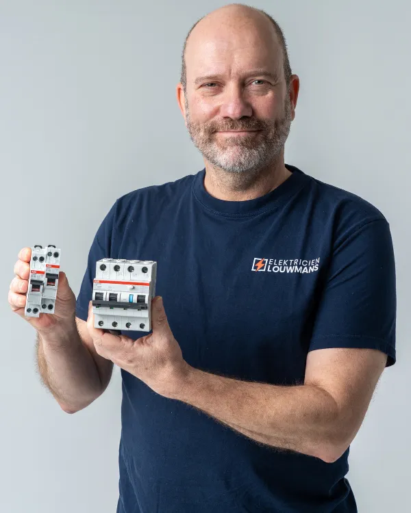 Elektricien houdt installatieautomaten voor een 3 fase aansluiting vast