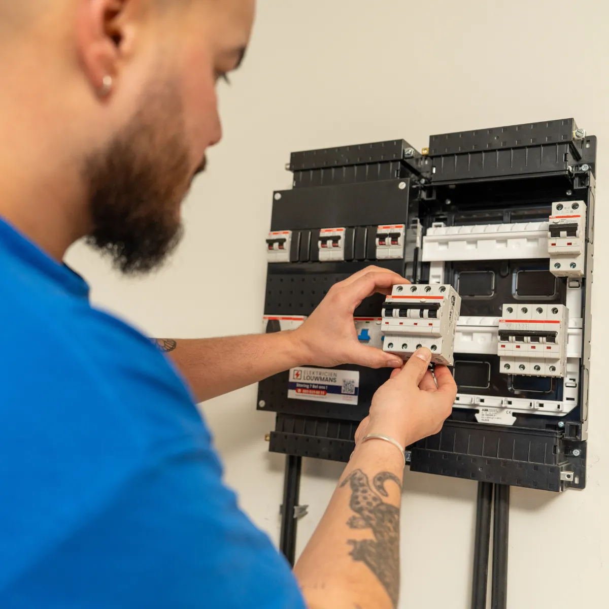 Elektricien plaatst een installatieautomaat in een nieuwe groepenkast